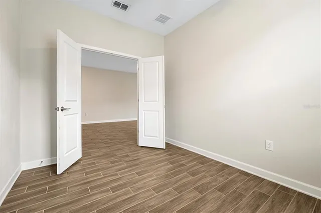 an empty room with wooden floor & closet