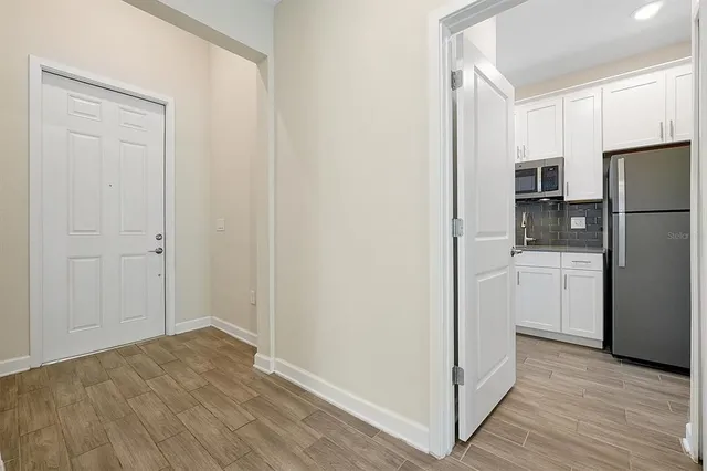 a view of a kitchen with wooden floor and a refrigerator