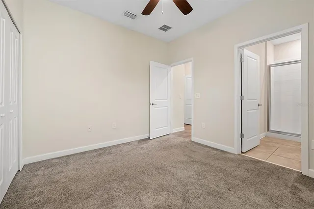 an empty room with chandelier fan
