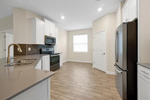 a kitchen with stainless steel appliances a refrigerator stove and sink