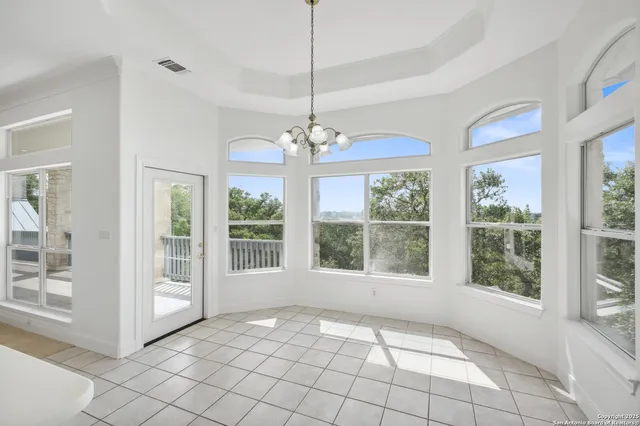 a bedroom with a large bed couch and two windows