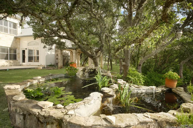 an empty room with a chandelier fan and windows