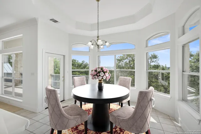 a front view of a house with potted plants and more windows