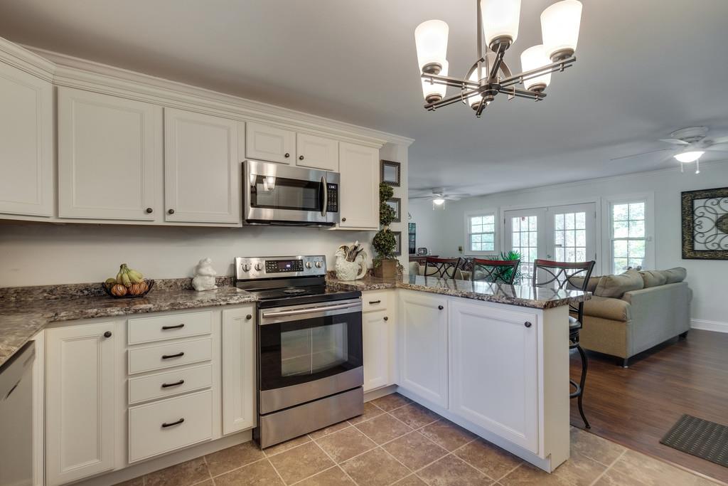 6615 Slaughter Road Santa Fe, TN 38482 - Photo 17 of 30 a kitchen with stainless steel appliances granite countertop a stove and cabinets