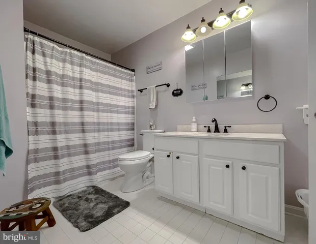 a bedroom with a large bed and flat tv screen on dresser