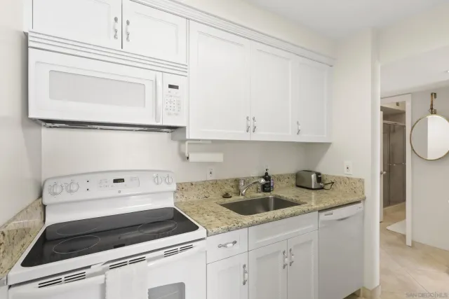 a kitchen with white cabinets and white appliances