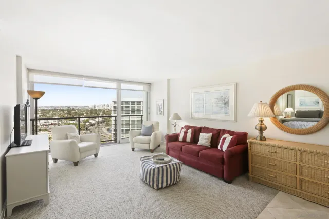 a living room with furniture a rug and a floor to ceiling window