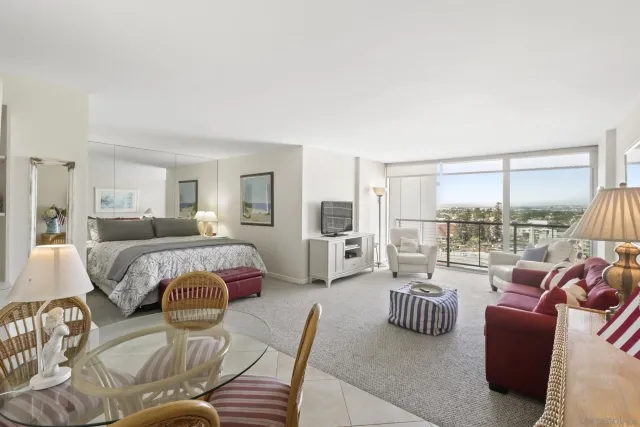 a bedroom with furniture and a large window