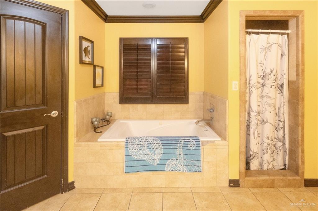 22811 Skinner Road Edcouch, TX 78538 - Photo 23 of 38 Soaking tub with tile surround, separate tiled shower, and wood-finish window shutters