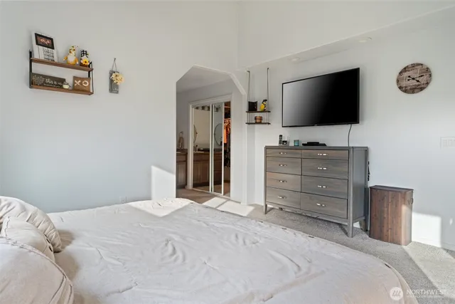 a bedroom with a bed and a flat screen tv