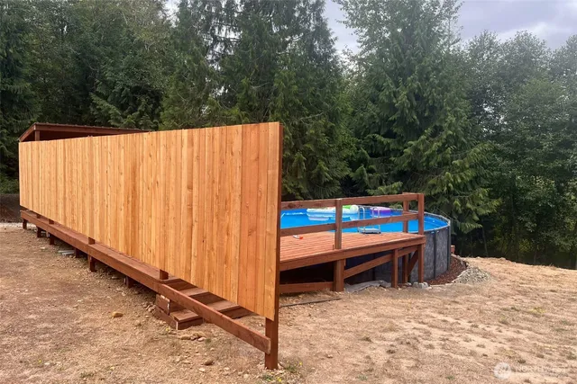a backyard of a house with wooden fence and trees