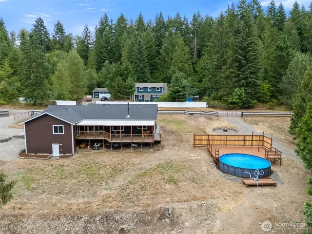 an aerial view of a house with swimming pool and big yard