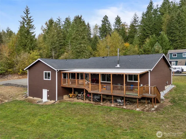 a view of a house with a yard and large trees