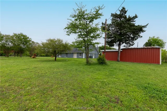 a view of backyard with huge green area and large trees