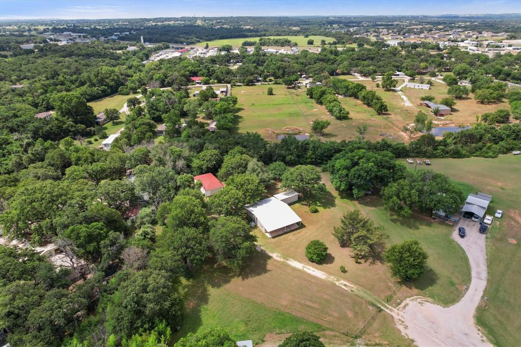 126 Smallwood Court Springtown, TX 76082 - Photo 24 of 24 Expansive acreage featuring multiple structures, mature trees, open fields, and a private pond