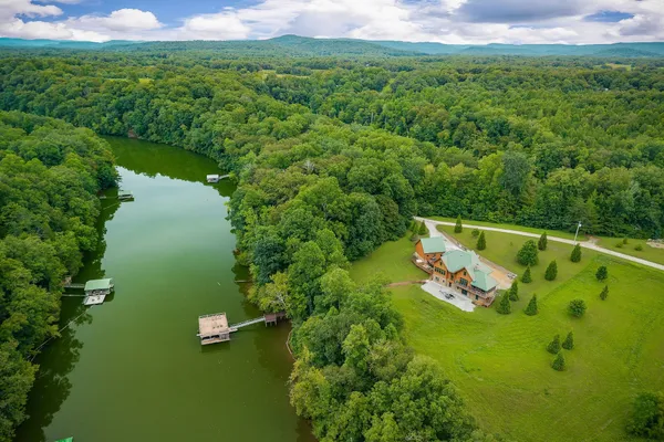 an aerial view of a house with swimming pool garden and mountain view in back