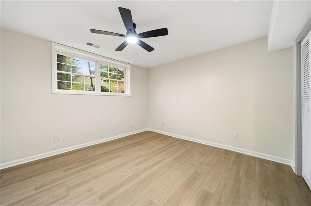 2089 Carthage Road Tucker, GA 30084 - Photo 28 of 38 an empty room with wooden floor ceiling fan and windows