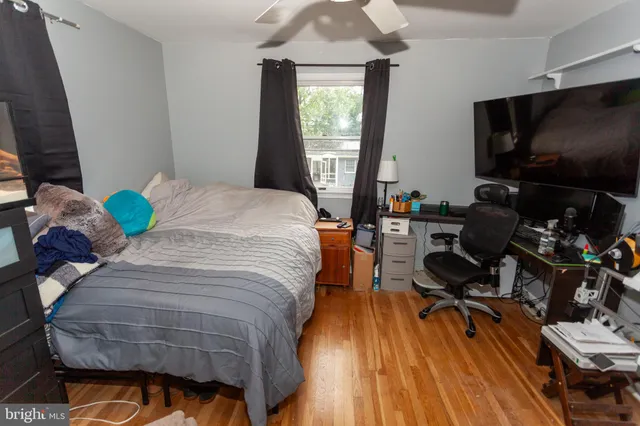 a bedroom with a bed and a flat tv screen on dresser