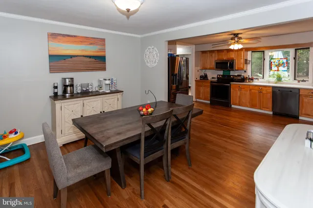 a kitchen with granite countertop a dining table chairs stainless steel appliances and cabinets