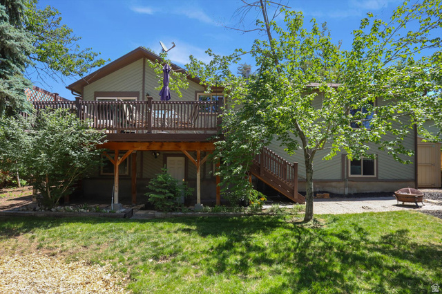 8938 Manchester Lane Sandy, UT 84093 - Photo 42 of 50 Rear exterior featuring a multi-level wood deck with railings, a lower concrete patio, and a landscaped yard with mature trees