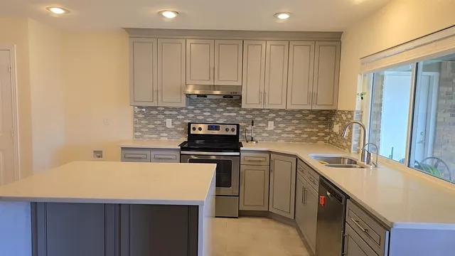 a kitchen with a sink dishwasher a stove and a refrigerator with wooden floor