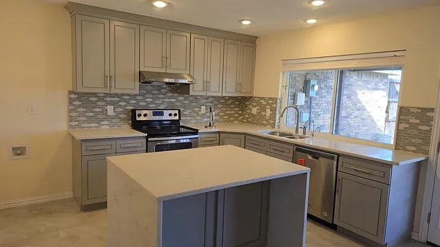 a kitchen with a sink cabinets and wooden floor
