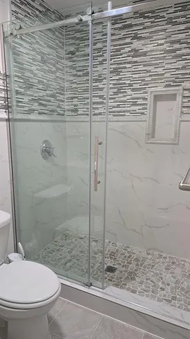 a bathroom with a toilet and a shower