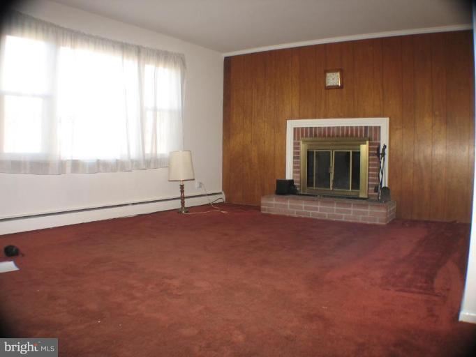 4131 Raleigh Road Pikesville, MD 21208 - Photo 3 of 11 an empty room with windows and fireplace