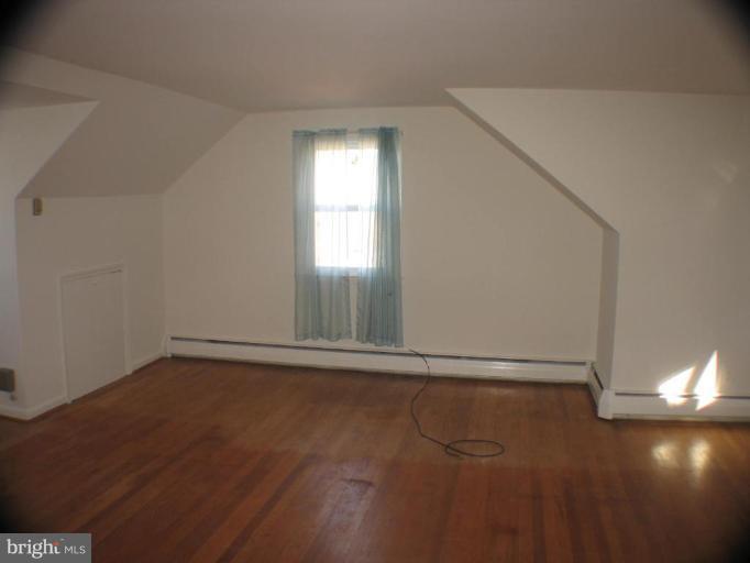 4131 Raleigh Road Pikesville, MD 21208 - Photo 7 of 11 a view of an empty room with wooden floor and a window
