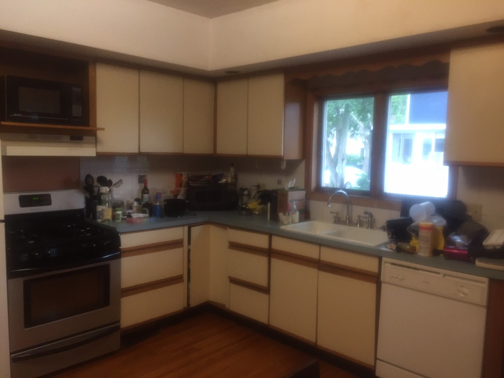 5 Arnold Street Arlington, MA 02476 - Photo 4 of 7 a kitchen with granite countertop white cabinets and black stainless steel appliances
