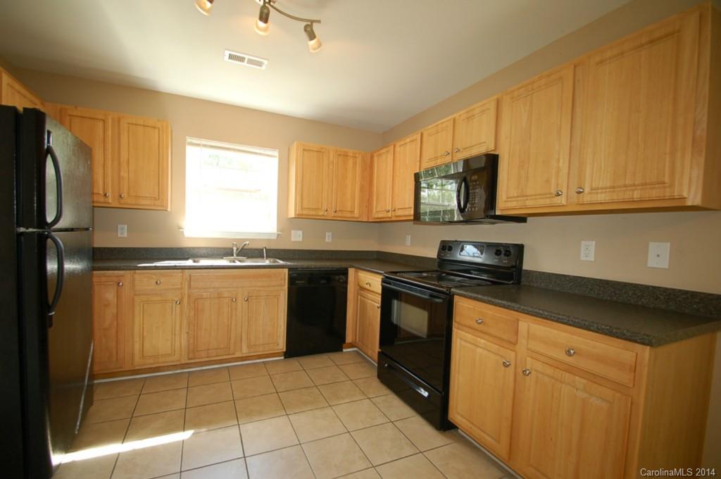 918 Valley Ridge Road Charlotte, NC 28214 - Photo 5 of 12 a kitchen with granite countertop a sink a stove top oven and cabinetry