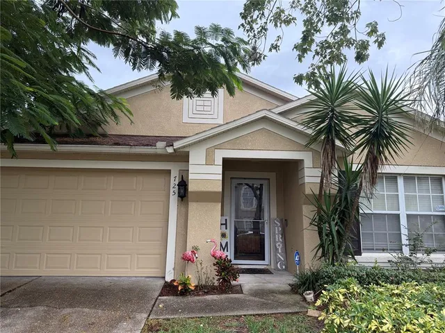 a front view of a house with a tree