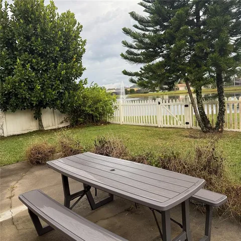 a view of backyard with wooden fence and a bench