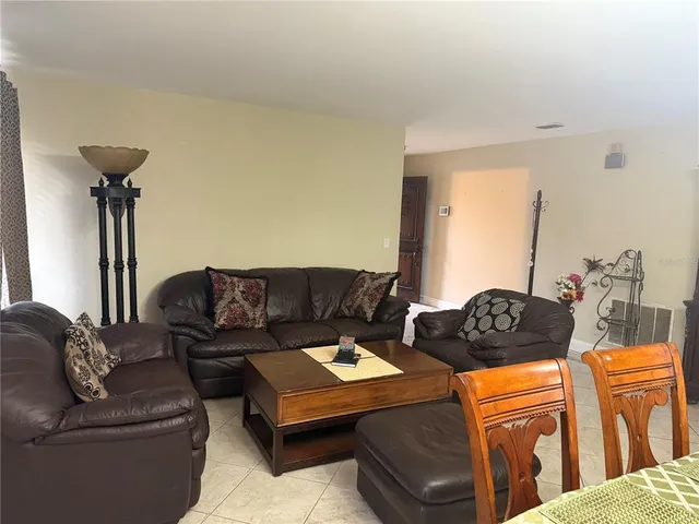 a living room with furniture and a mirror