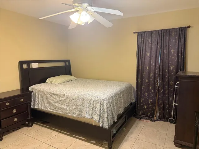 a bed sitting in a bedroom next to a window and a chandelier