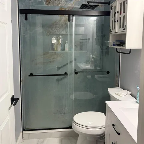 a bathroom with a shower a toilet and a sink