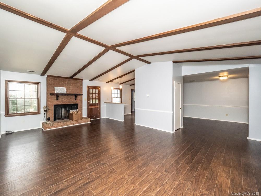 1300 Rock Point Road Charlotte, NC 28270 - Photo 4 of 13 an empty room with wooden floor fireplace and windows