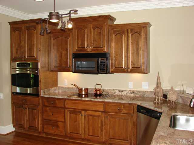 1137 Wakefield Farm Road Zebulon, NC 27597 - Photo 6 of 10 Custom Stained kitchen cabinets with granite tops. Smooth surface cooktop with all stainless appliances.