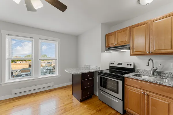 a kitchen with stainless steel appliances granite countertop a stove a sink and a microwave