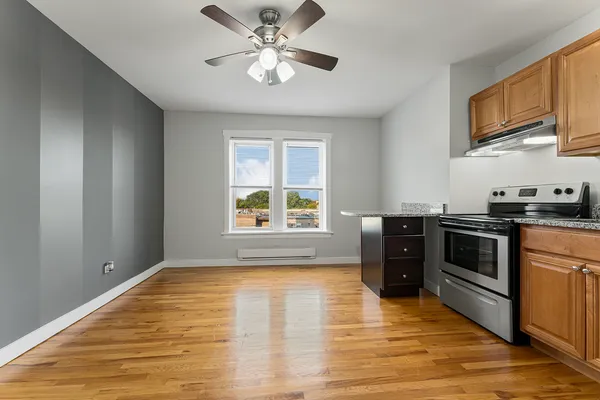 a kitchen with stainless steel appliances granite countertop a stove a sink and a microwave