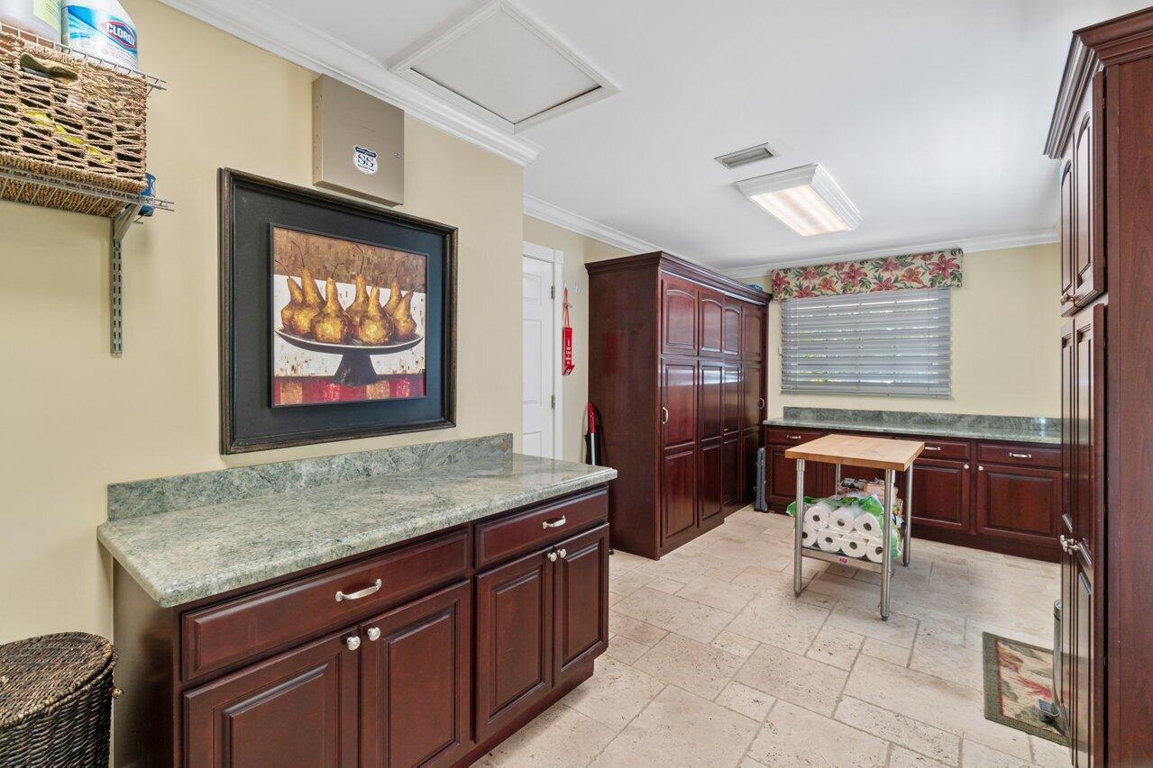 5861 Roebuck Road Jupiter, FL 33458 - Photo 11 of 74 a living room with stainless steel appliances kitchen island granite countertop a refrigerator a stove and wooden cabinets