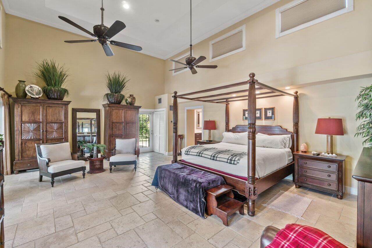 5861 Roebuck Road Jupiter, FL 33458 - Photo 22 of 74 a bedroom with a bed a couch and potted plant