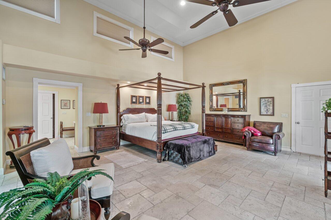 5861 Roebuck Road Jupiter, FL 33458 - Photo 23 of 74 a bedroom that has a bed and a chandelier