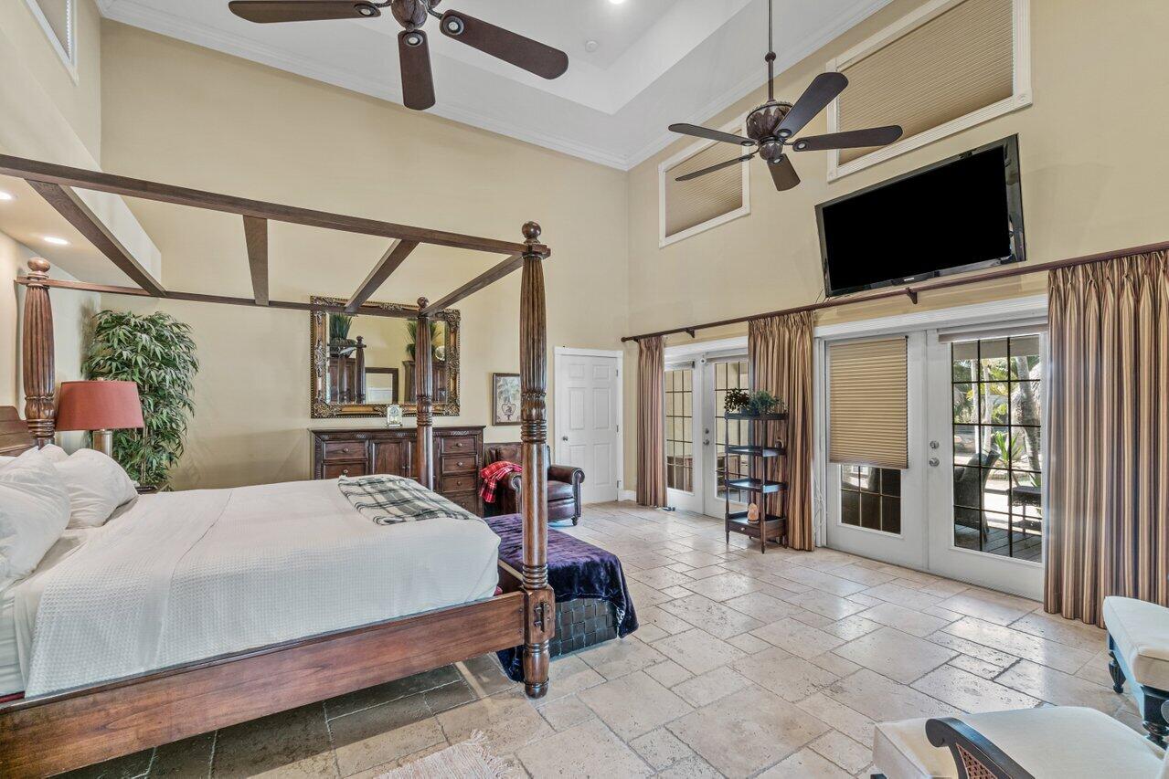 5861 Roebuck Road Jupiter, FL 33458 - Photo 24 of 74 a bedroom with a bed a flat screen tv and a window