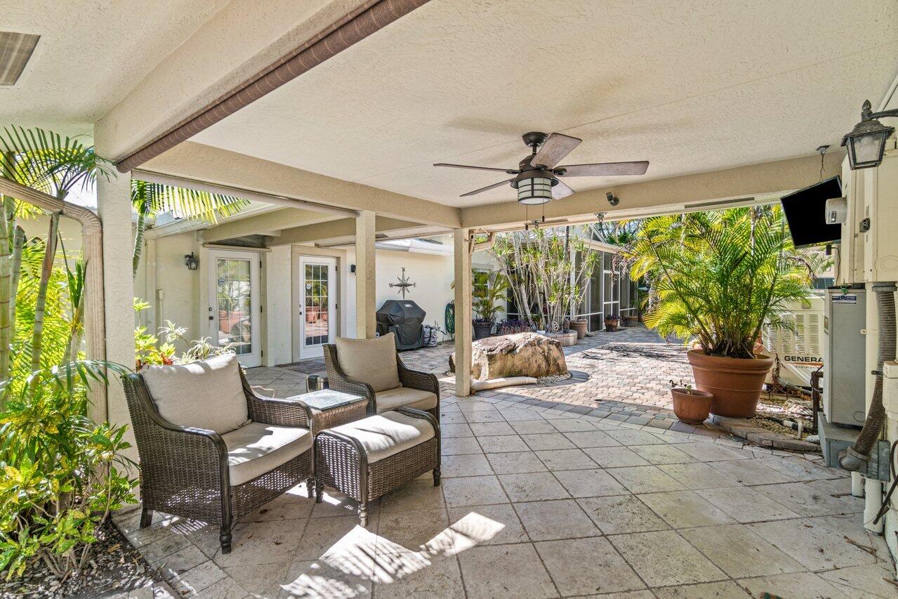 5861 Roebuck Road Jupiter, FL 33458 - Photo 42 of 74 a living room with patio furniture and a potted plants
