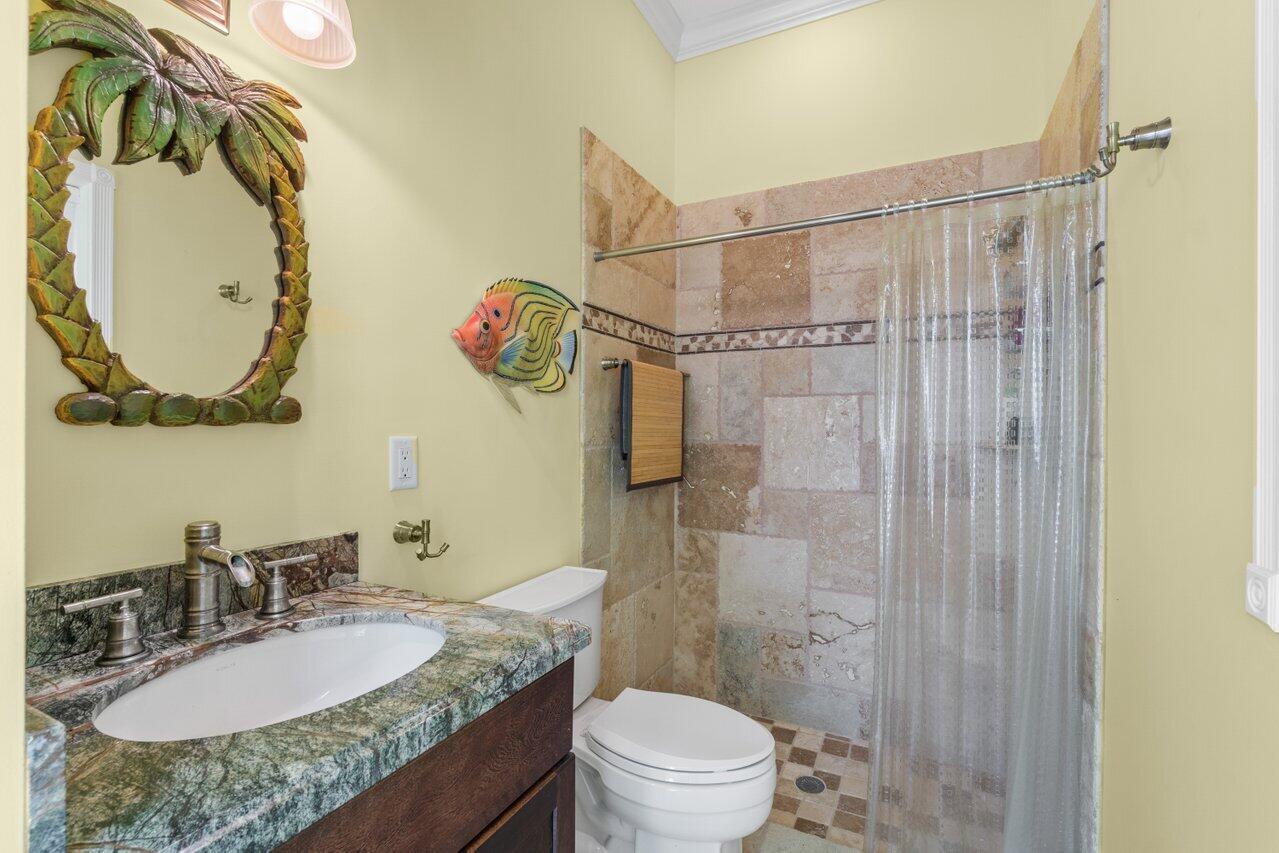 5861 Roebuck Road Jupiter, FL 33458 - Photo 43 of 74 a bathroom with a granite countertop sink a toilet and shower