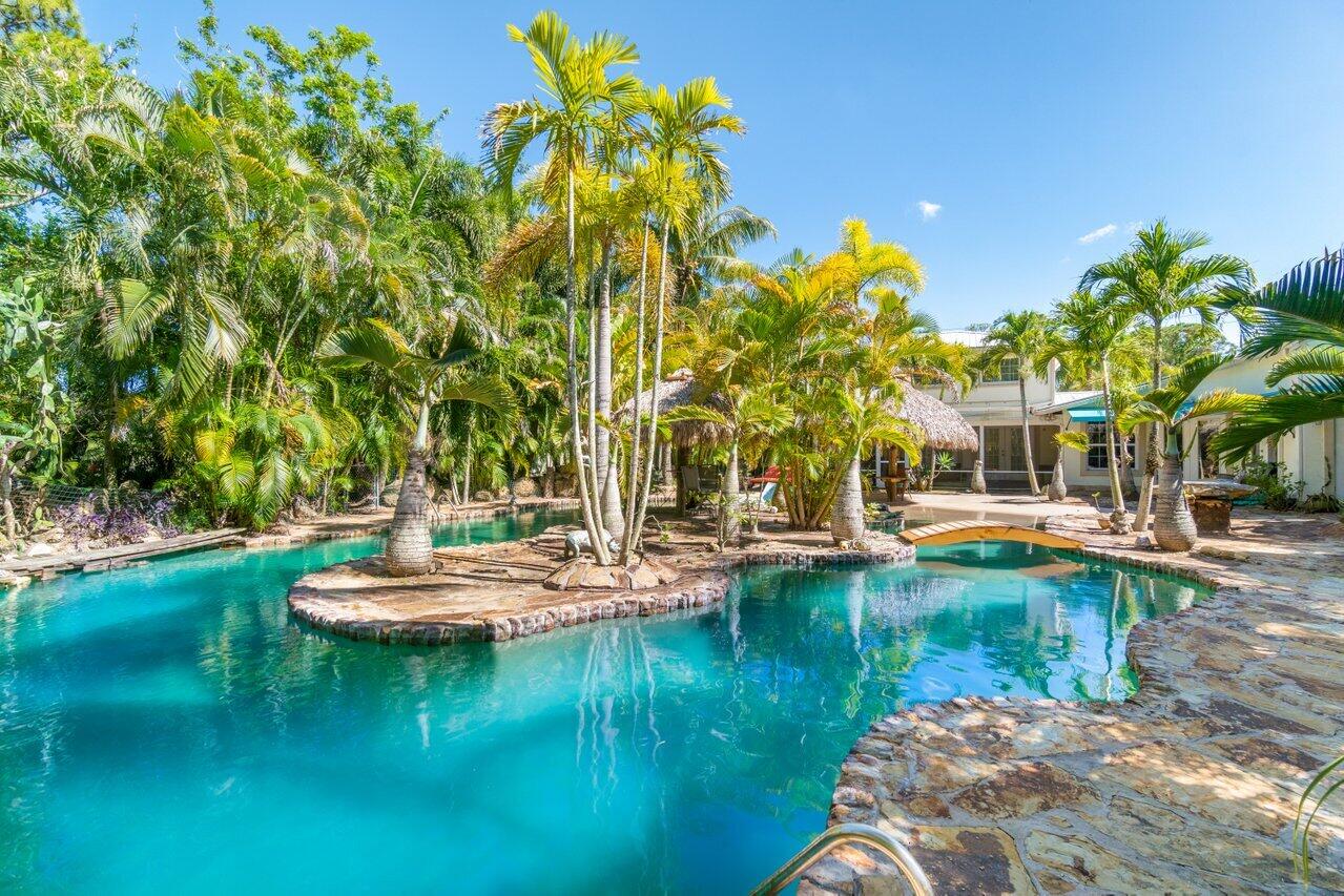 5861 Roebuck Road Jupiter, FL 33458 - Photo 47 of 74 a view of swimming pool with lawn chairs and plants