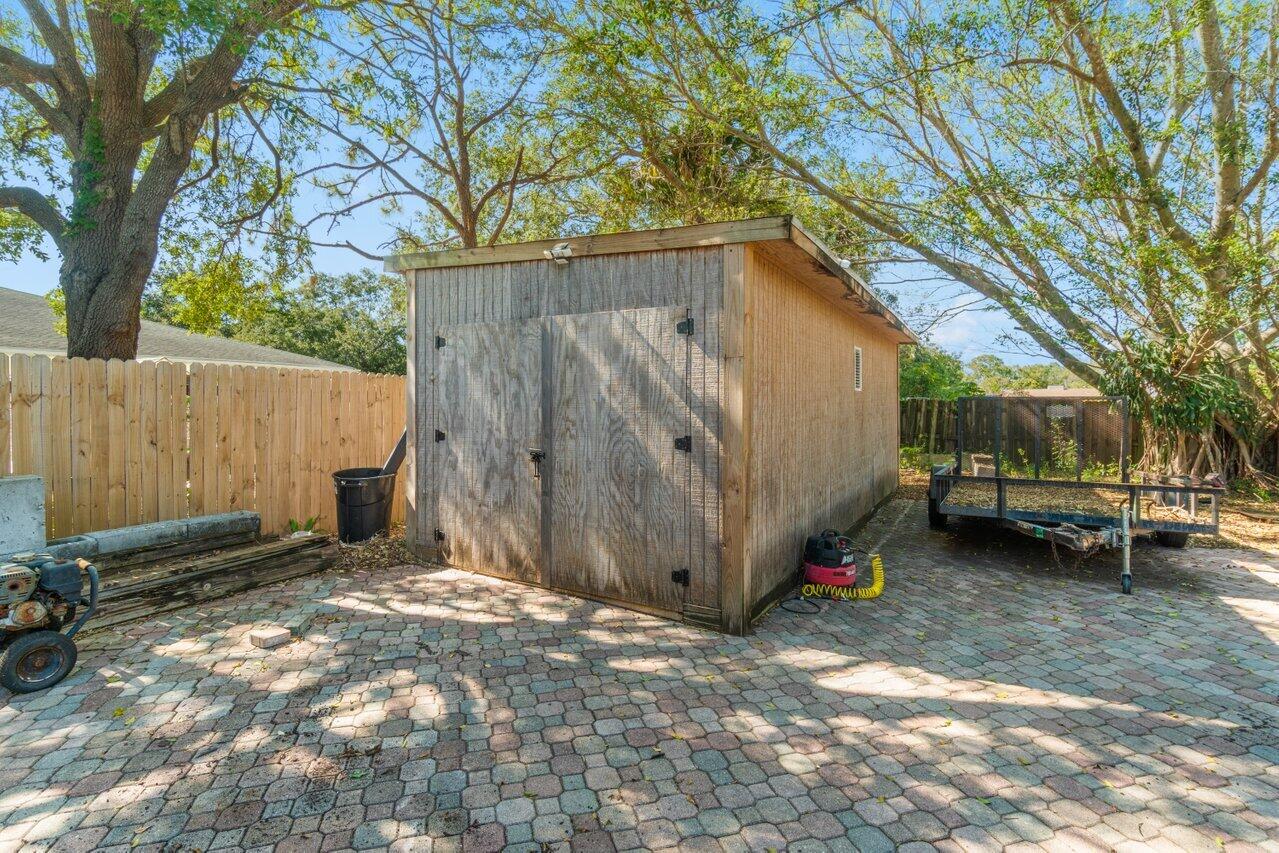 5861 Roebuck Road Jupiter, FL 33458 - Photo 56 of 74 a view of a backyard with large trees and a small barn