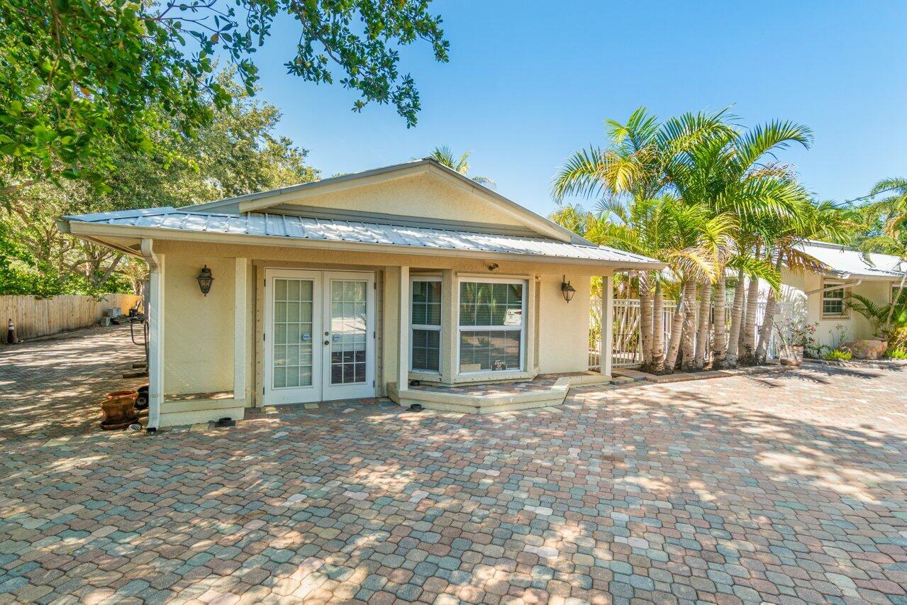 5861 Roebuck Road Jupiter, FL 33458 - Photo 60 of 74 a front view of a house with a garden