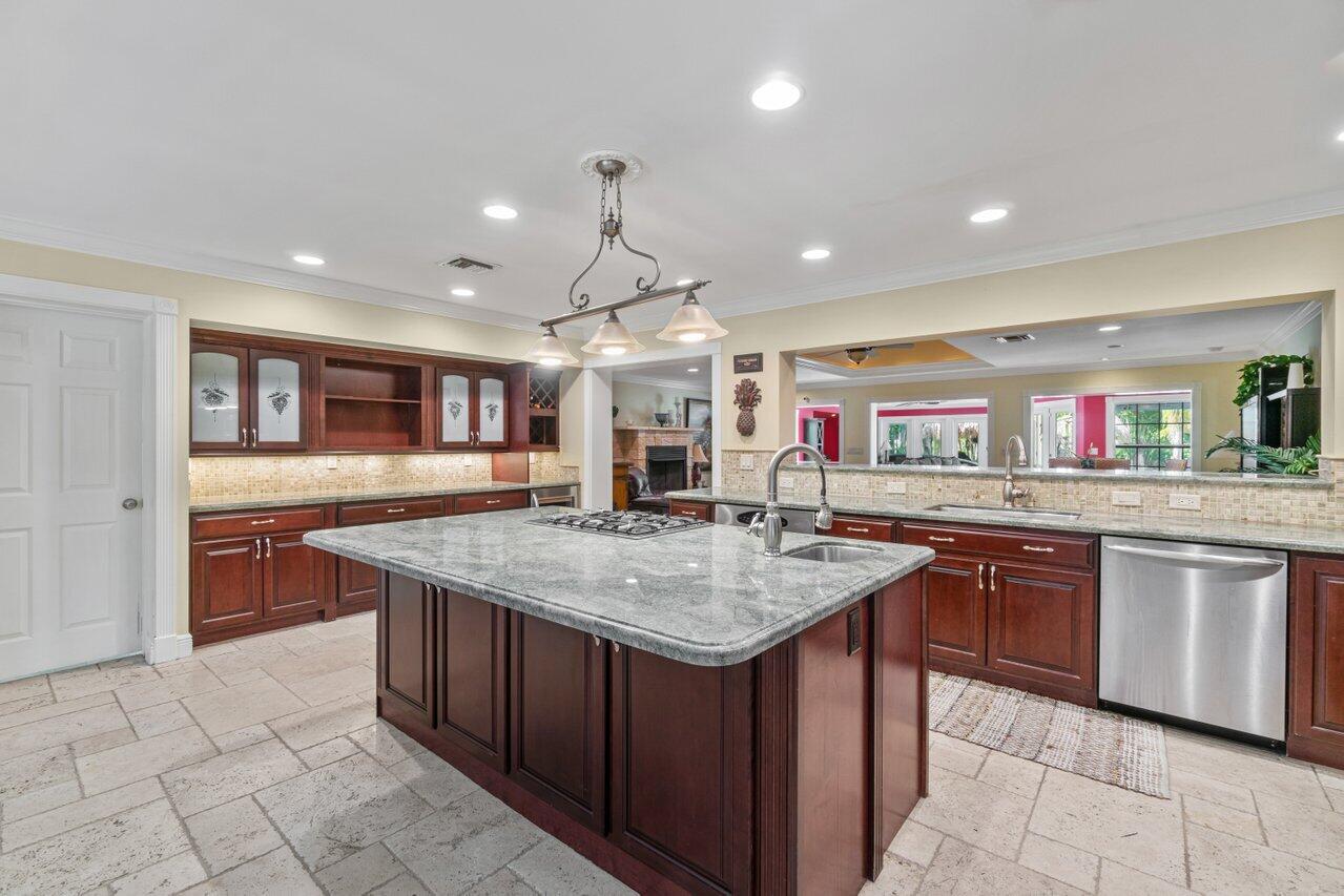 5861 Roebuck Road Jupiter, FL 33458 - Photo 8 of 74 a kitchen with stainless steel appliances granite countertop a sink and stove